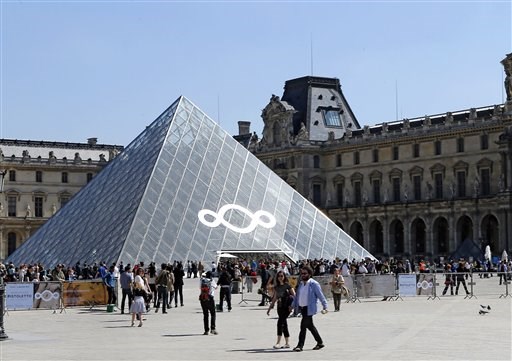 Una pieza de la instalación del artista italiano Michelangelo Pistoletto "Year 1, Heaven on Earth" decora la famosa pirámide de cristal del museo del Louvre en París, el miércoles 24 de abril de 2013. La instalación de Pistoletto es una crítica a la codicia financiera que llevó a la actual crisis económica mundial. (Foto AP/Jacques Brinon)